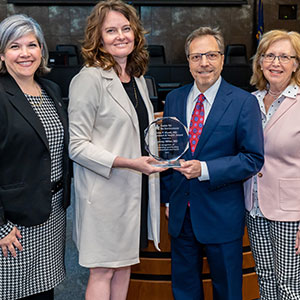 From left, Kelly Pennell, Erin Haynes, Aubrey Miller and Ellen Hahn present award to Miller.