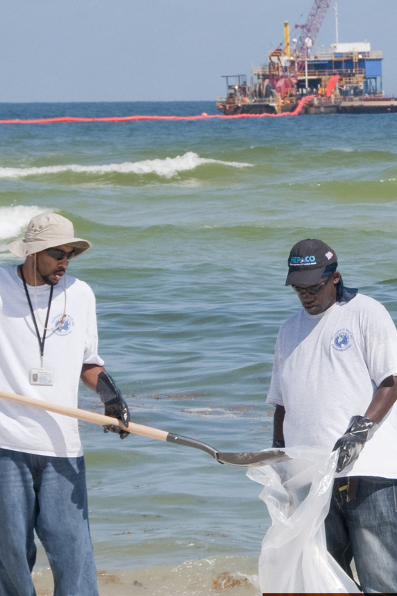 Two workers cleaning up beach